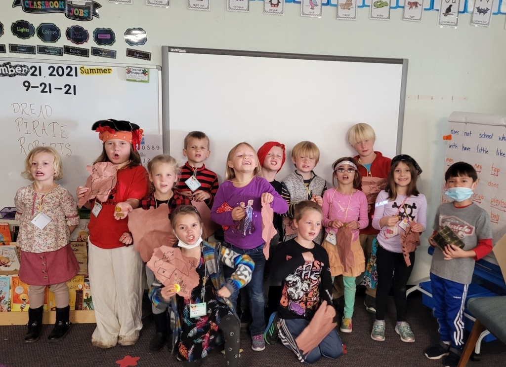 Children holding treasure maps and pirate gold 