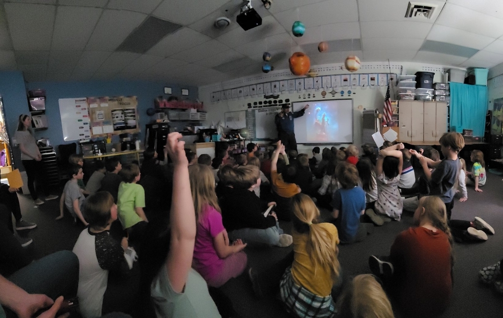 astronaut speaking to elementary students 